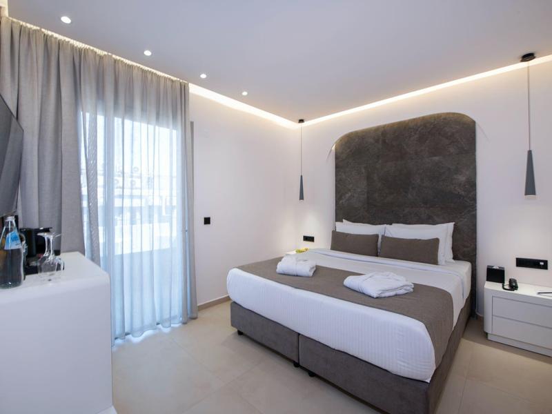 Modern bedroom with double bed, sideboards, and large windows with curtains.