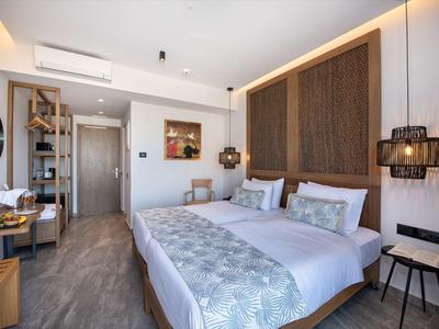 Modernes Hotelzimmer mit Doppelbett, Holzakzenten und minimalistischem Design.