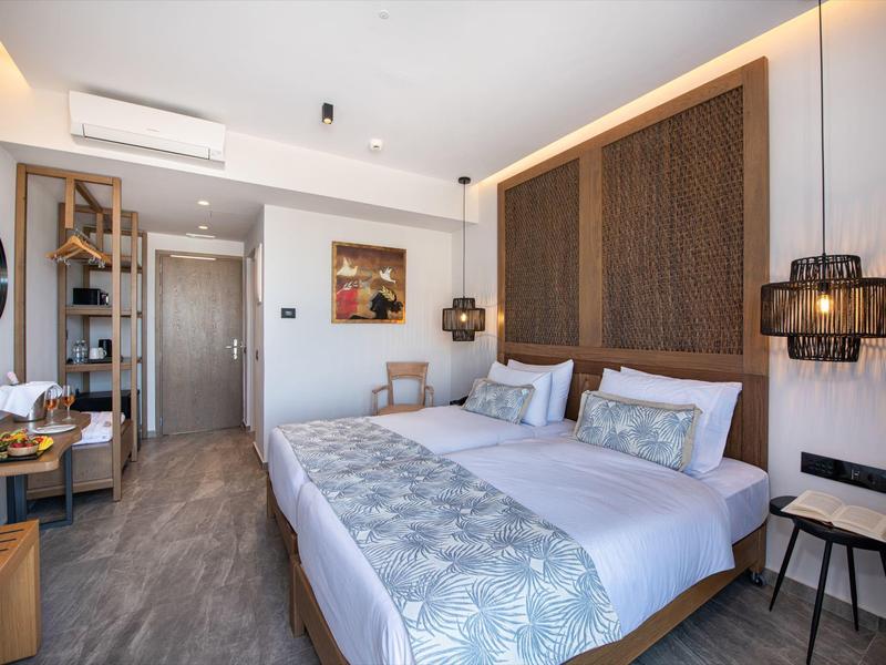 Modernes Hotelzimmer mit Doppelbett, Holzakzenten und minimalistischem Design.