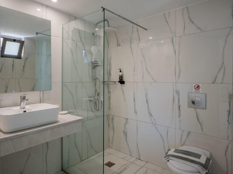 Nowoczesna łazienka z prysznicem, umywalką i toaletą w neutralnych kolorach