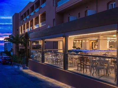 Hotel restaurant at dusk with street view and open seating areas.