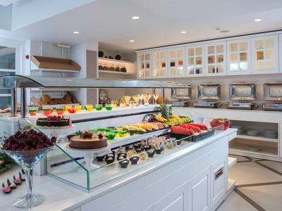 Bright hotel kitchen with buffet stations and a wide selection of food and drinks.