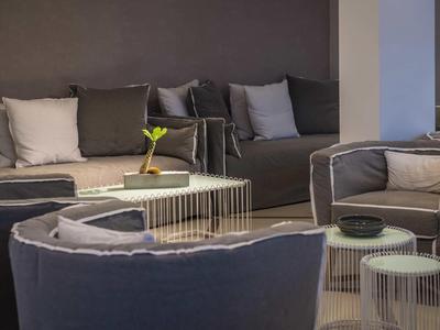 Gemütlicher Lounge-Bereich mit grauen Sofas und Beistelltischen in einem Hotel.