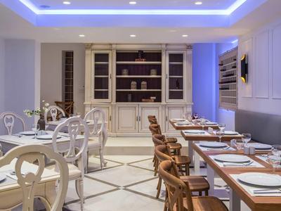 Elegant restaurant interior with set tables and stylish chairs in a bright setting.