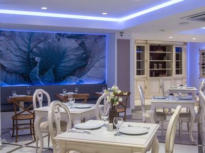 Elegant restaurant with white furniture and large blue flower artwork on the wall.