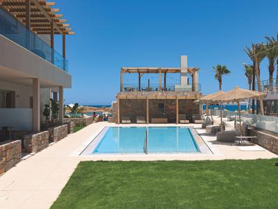 Piscina exterior moderna con tumbonas y pérgola en hotel soleado.