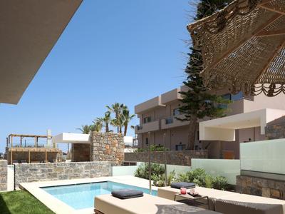 Moderní venkovní prostor s malým bazénem, lehátky a rostlinami v obytném komplexu.