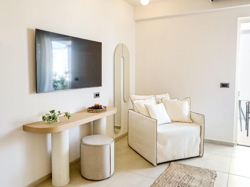Bright, modern living room with sofa, wall mirror, and sleek console table.