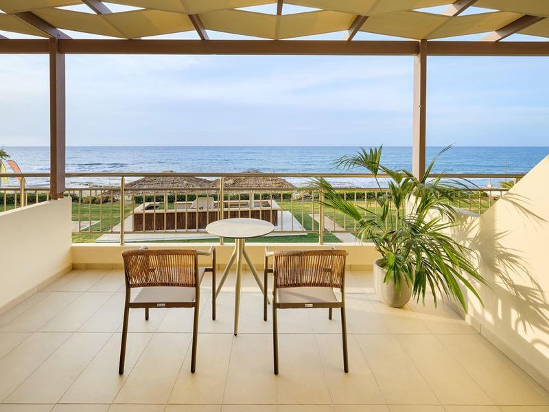 Terrace with table, two chairs, and a clear view of the sea.