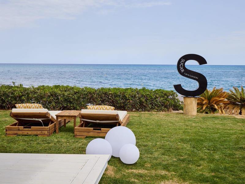 Beach loungers on grass overlooking the sea with a large letter S decoration