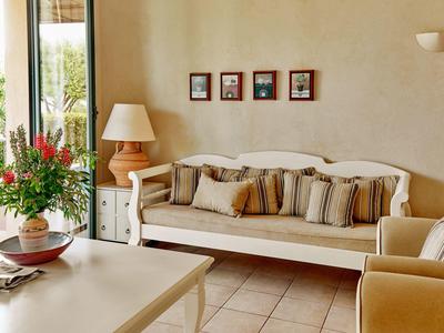 Soggiorno accogliente con divano bianco, cuscini a righe e composizione floreale sul tavolo.