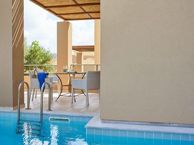 Vista su una piscina con terrazza, sedie e tavolo in un'area dell'hotel.
