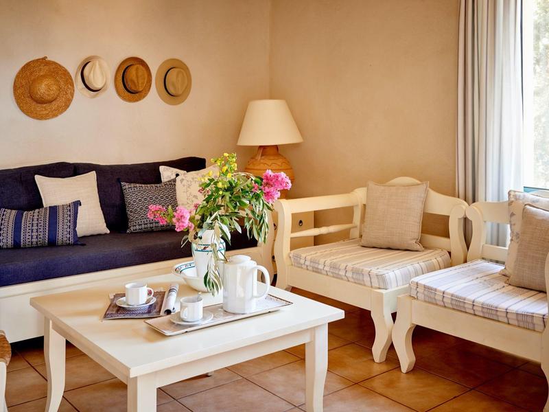 Accogliente soggiorno con divani, tavolo e cappelli decorativi a parete