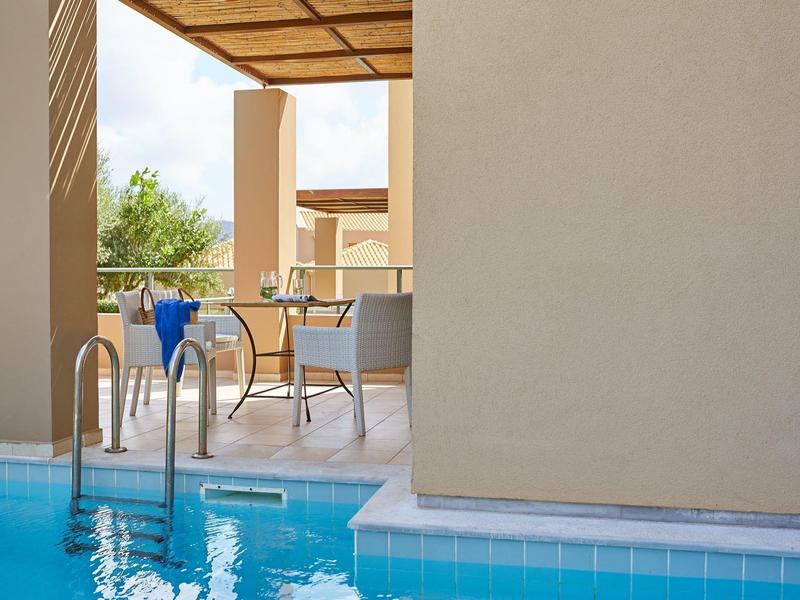 Vista su una piscina con terrazza, sedie e tavolo in un'area dell'hotel.