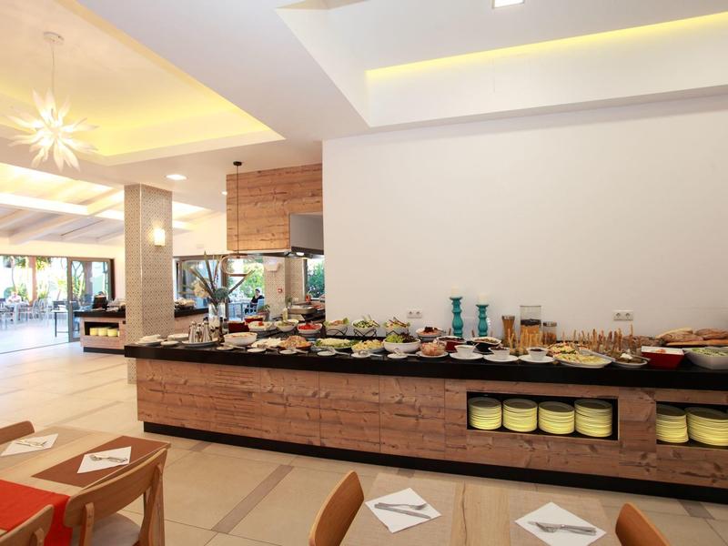 Licht ontbijtzaal met buffet en zitplaatsen in modern hotel.