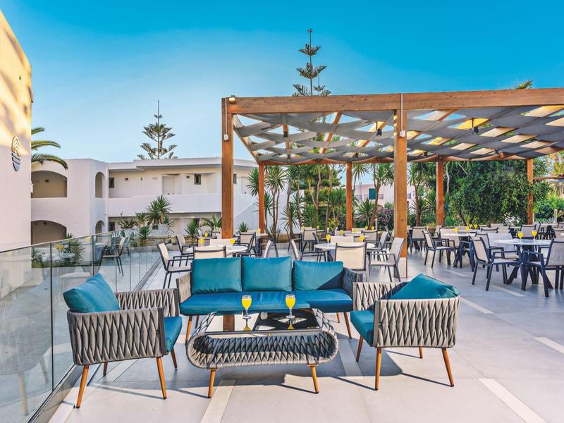 Moderne buitenruimte met blauwe zitmeubels en pergola in een hotel.