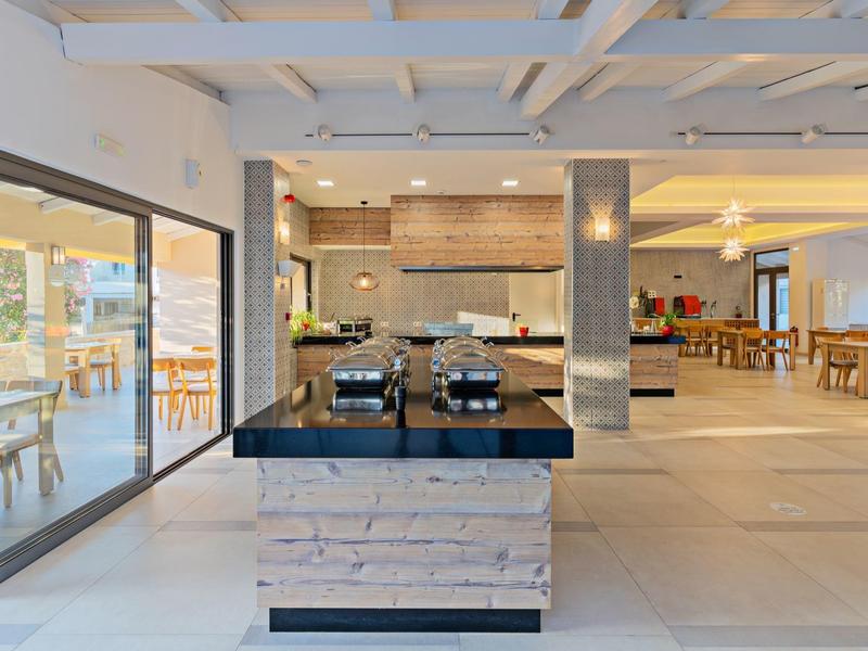 Heldere, moderne hotelrestaurantinterieur met buffet en zitplaatsen.