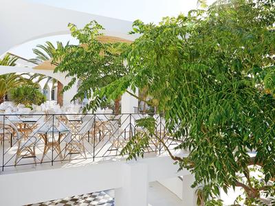 Balkon s stolky a židlemi za zeleným listím, ideální pro relaxaci venku.