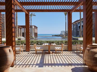 Vista sul mare da una terrazza coperta con doghe di legno e due grandi vasi