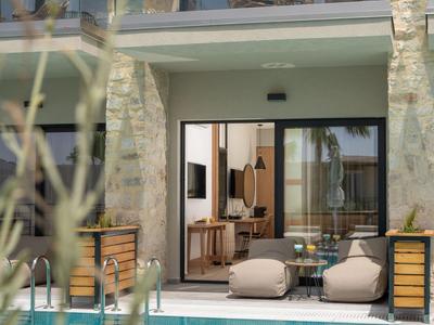 Moderní venkovní prostor s bazénem, posezením a výhledem do hotelových pokojů.