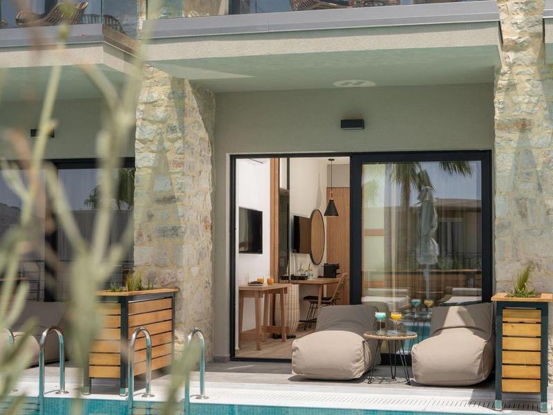 Moderní venkovní prostor s bazénem, posezením a výhledem do hotelových pokojů.