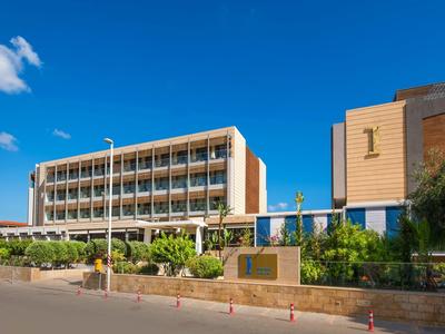 Nowoczesny budynek hotelu z zielonym ogrodem i błękitnym niebem.