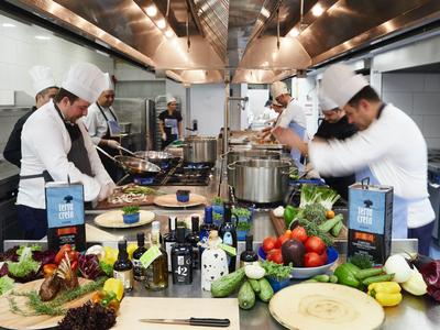 Kucharze w profesjonalnej kuchni przygotowujący dania z świeżych składników na stole.