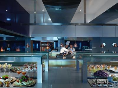 Restaurant d'hôtel moderne avec bar élégant et éclairage d'ambiance nocturne.