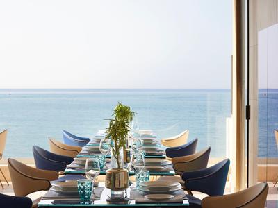 Restaurant moderne avec vue sur la mer et tables élégamment dressées.