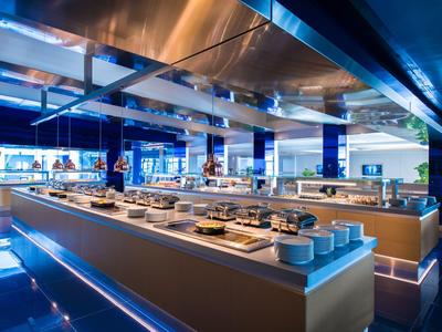 Buffet moderne avec plats variés et éclairage bleu dans un restaurant d'hôtel.