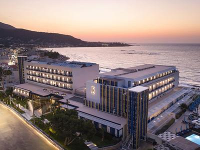 Bâtiment d'hôtel moderne sur la plage avec vue sur la mer au coucher du soleil.