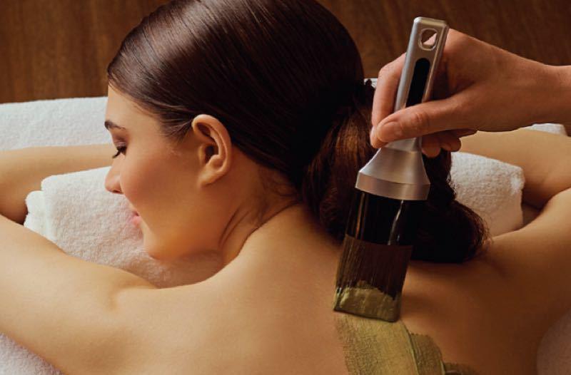 Kobieta otrzymuje masaż pleców w spa, relaksująca i spokojna atmosfera.