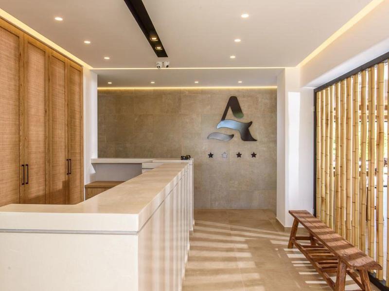 Moderne hotelreceptie met lichte kleuren, houten details en minimalistische inrichting.