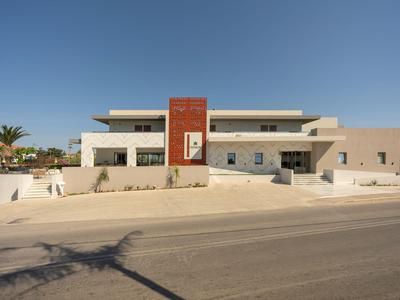 Hôtel moderne et plat avec façade claire et accents rouges sous un ciel dégagé.
