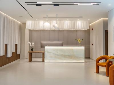 Réception d'hôtel lumineuse avec comptoir en marbre, design moderne et espace assis.