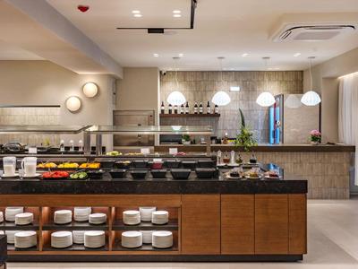 Espace petit-déjeuner moderne avec buffet dans un hôtel, design lumineux et épuré.