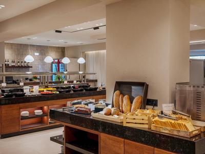 Espace buffet avec une sélection de pains frais et pâtisseries dans un hôtel moderne