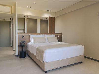 Chambre d'hôtel moderne avec grand lit double et décoration minimaliste.