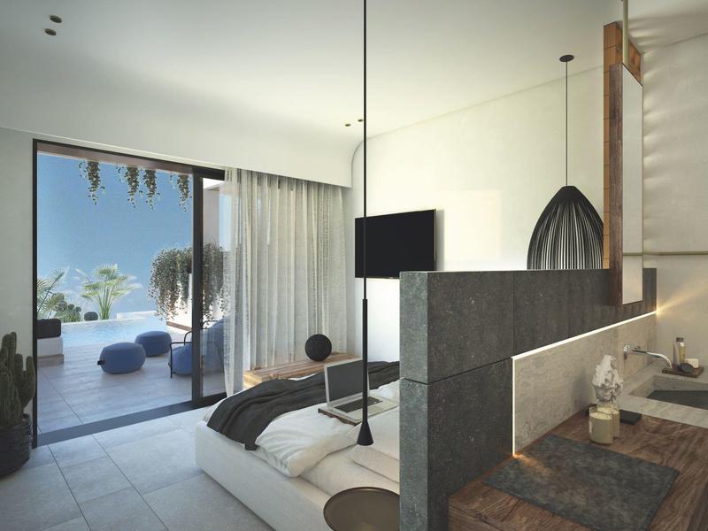 Habitación de hotel moderna con cama doble, baño abierto y terraza con vista al mar.