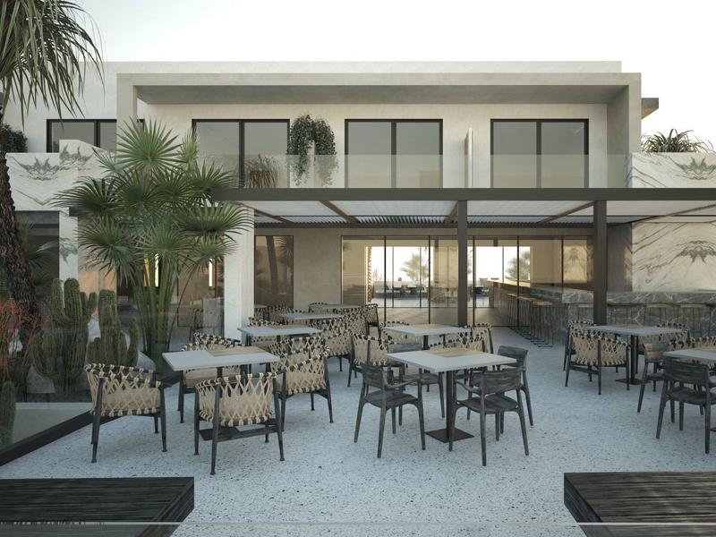 Área exterior moderna de hotel con mesas, sillas y palmeras al anochecer.