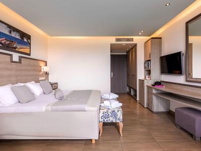 Camera d'hotel moderna con letto matrimoniale, TV e illuminazione elegante.