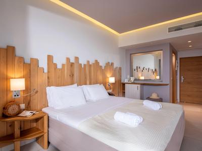 Modernes Hotelzimmer mit Doppelbett, Holzkopfteil und sanfter Beleuchtung.