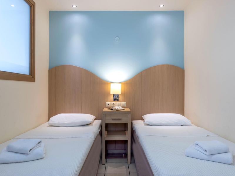 Camera doppia con due letti singoli, comodino e illuminazione soffusa