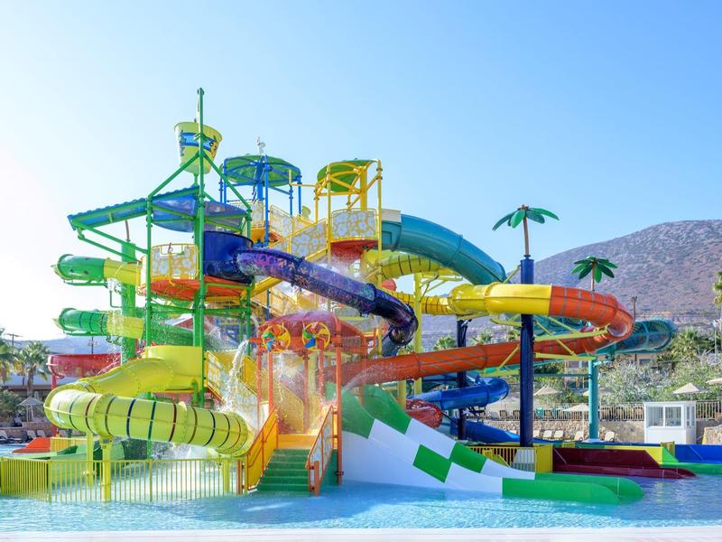 Complesso di scivoli d'acqua colorati con più scivoli e piscina in un resort.