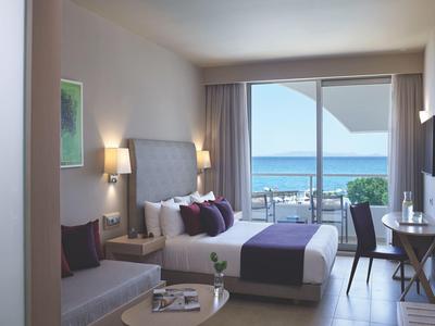 Gezellige hotelkamer met tweepersoonsbed en balkon met uitzicht op zee