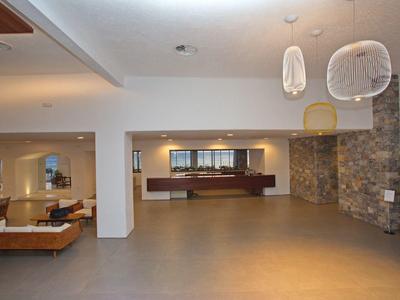 Nowoczesna, przestronna lobby hotelowa z miejscami do siedzenia i dekoracjami na ścianach.