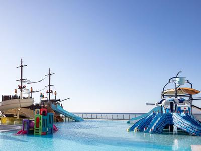 Park wodny z zjeżdżalniami i statkiem pirackim w basenie pod czystym niebem.