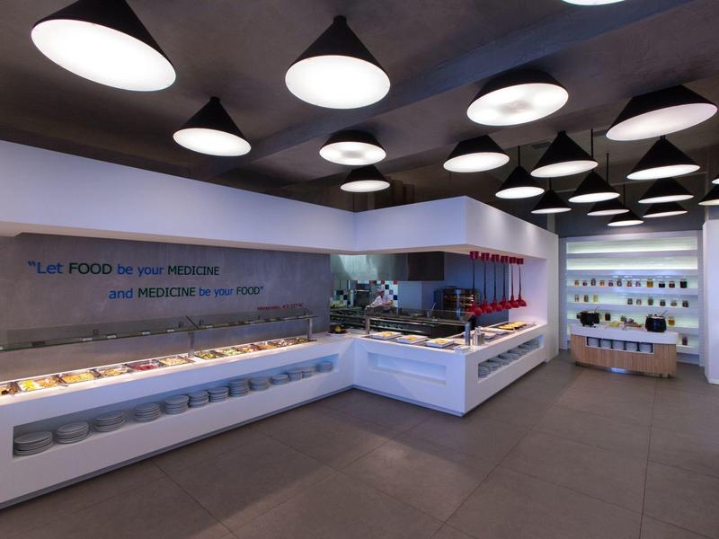 Nowoczesna jadalnia z bufetem i stylowym oświetleniem sufitowym.