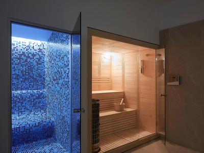 Moderne sauna en blauwe stoomruimte in een rustige wellnessruimte.
