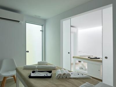 Moderne kamer met massagetafel, handdoeken en aparte badkamer.